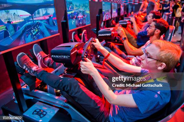 Visitorr tries a car racing video game at 2018 gamescom fair press day on August 21, 2018 in Cologne, Germany. Gamescom is Europe's biggest trade...