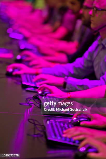 Visitors sit in a row and try video games at 2018 gamescom fair press day on August 21, 2018 in Cologne, Germany. Gamescom is Europe's biggest trade...