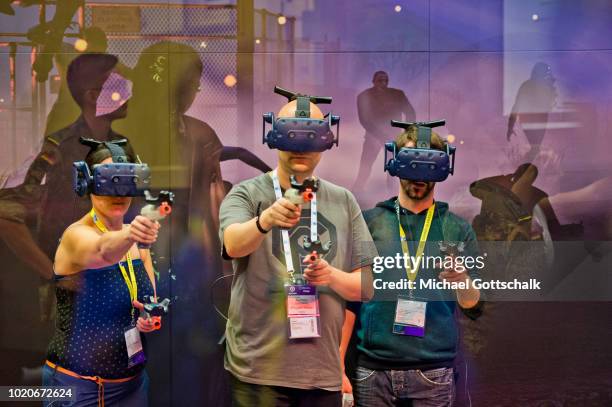 Visitors try virtual reality video games at 2018 gamescom fair press day on August 21, 2018 in Cologne, Germany. Gamescom is Europe's biggest trade...