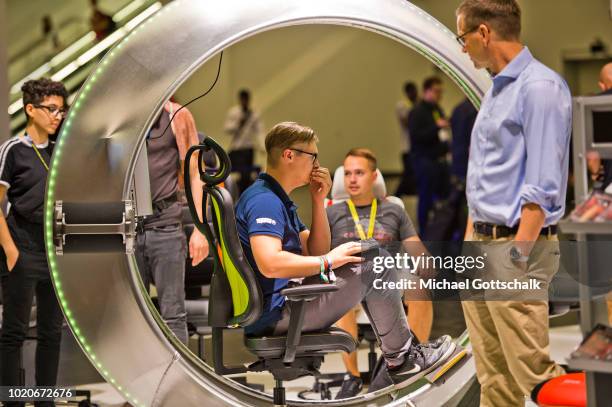 Visitors try gaming chairs at 2018 gamescom fair press day on August 21, 2018 in Cologne, Germany. Gamescom is Europe's biggest trade fair for the...