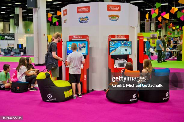 Visitors try video games at Nintendo booth at 2018 gamescom fair press day on August 21, 2018 in Cologne, Germany. Gamescom is Europe's biggest trade...