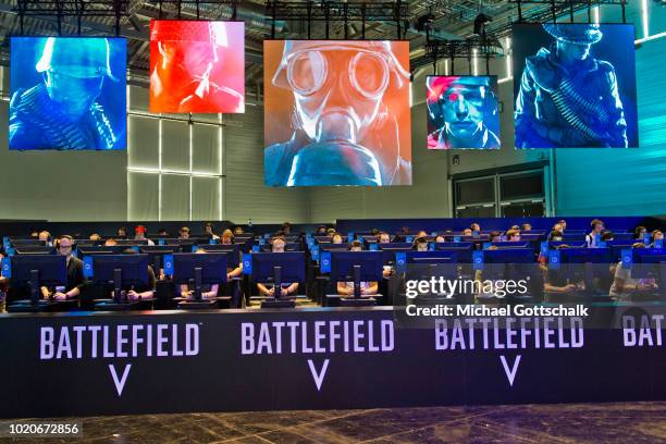 Visitors try battlefield video game at 2018 gamescom fair press day on August 21, 2018 in Cologne, Germany. Gamescom is Europe's biggest trade fair...