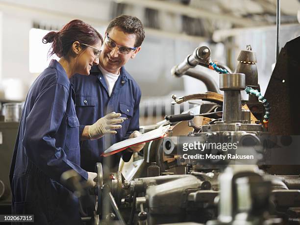engineer teaching female apprentice - manufacturing machinery stockfoto's en -beelden