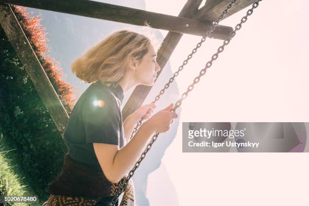 young woman swinging on swing - woman on swing stock pictures, royalty-free photos & images