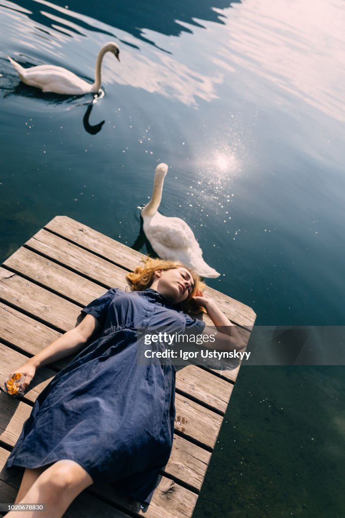 Young woman sunbathing on jetty