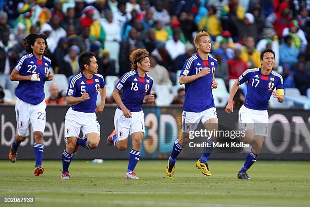 Keisuke Honda of Japan celebrates with team mates Yuji Nakazawa, Yuto Nagatomo, Yoshito Okubo and Makoto Hasebe after scoring the opening goal during...