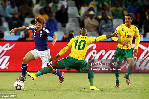 Yoshito Okubo of Japan evades the tackle by Achille Emana of Cameroon during the 2010 FIFA World Cup South Africa Group E match between Japan and...
