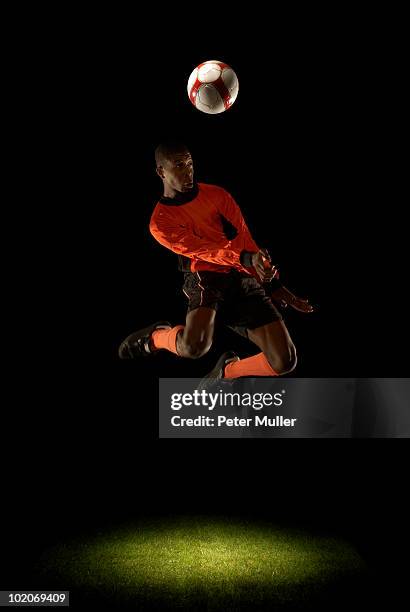 footballer jumping for header - geköpft stock-fotos und bilder