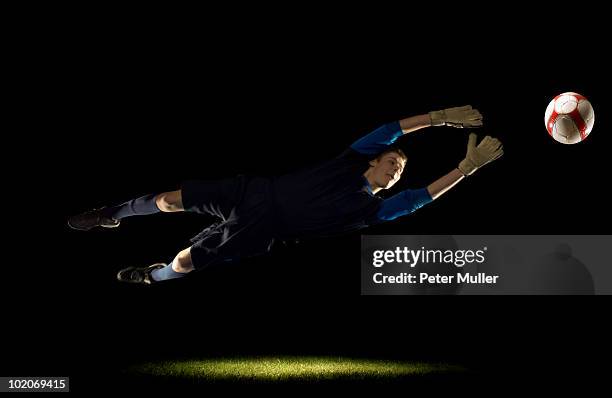 goalkeeper diving for ball - naar de grond duiken stockfoto's en -beelden