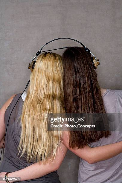 teen friends share listen to music - girl long hair stock pictures, royalty-free photos & images