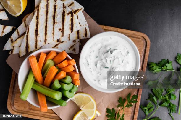 yogurt sauce with parsley served with fresh carrot and celery sticks - たれ ストックフォトと画像