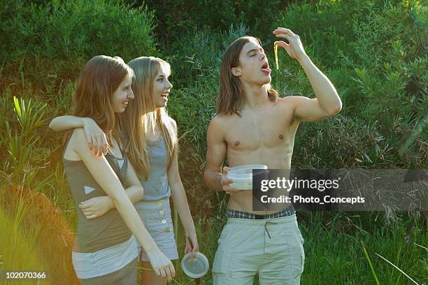 young man pretending to eat weeds - unpleasant taste stock pictures, royalty-free photos & images