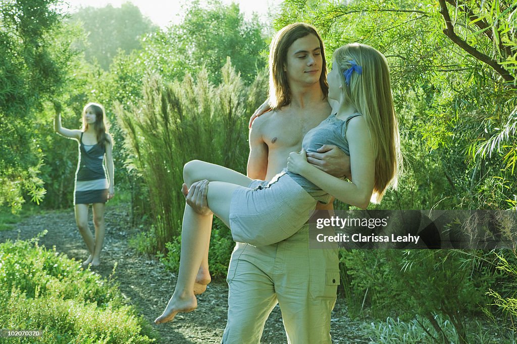 Young man carrying young woman