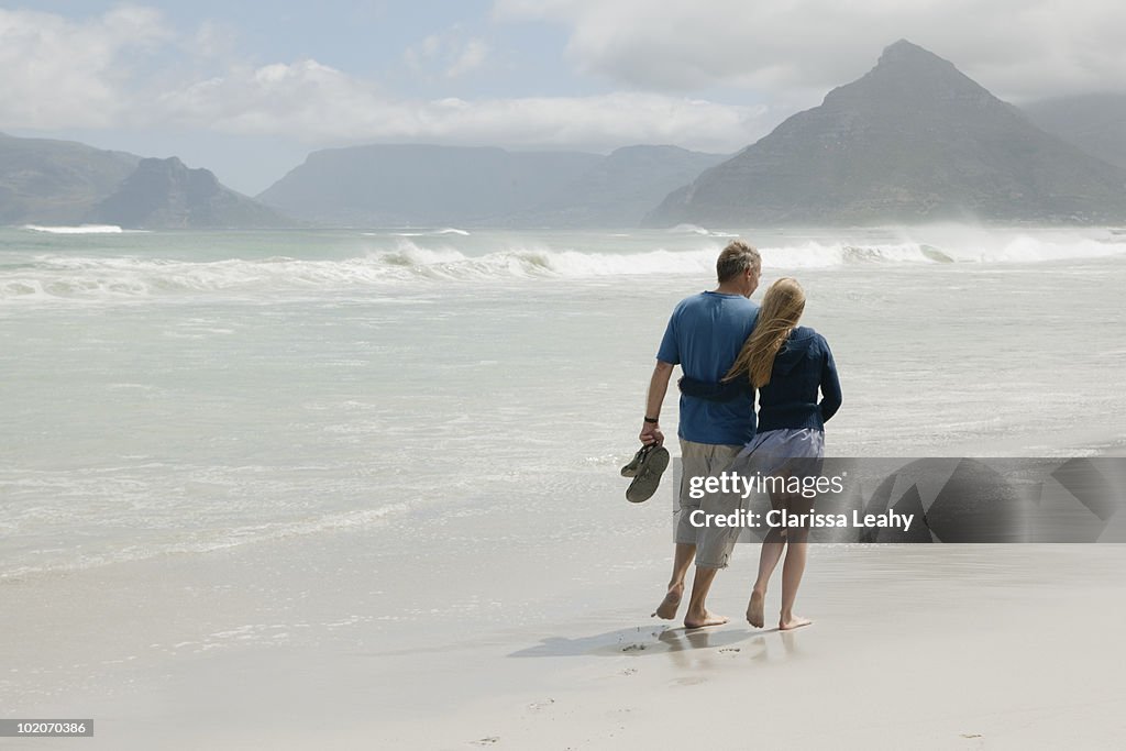 Young woman walking on beach with father