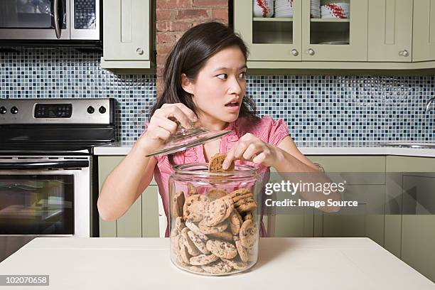 young woman with cookie jar - pot met koekjes stockfoto's en -beelden