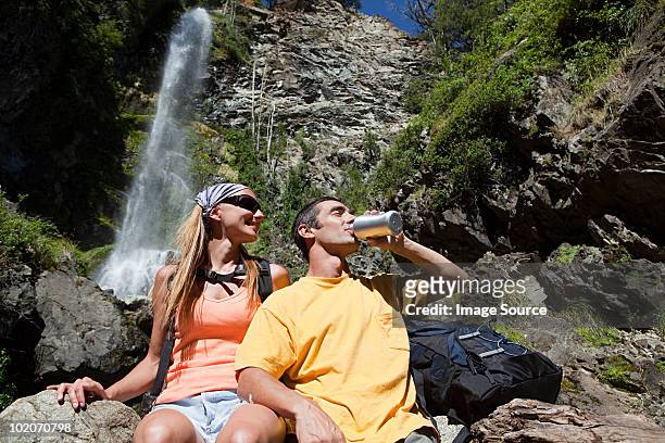 par disfruta de una bebida junto a la cascada - bariloche fotografías e imágenes de stock