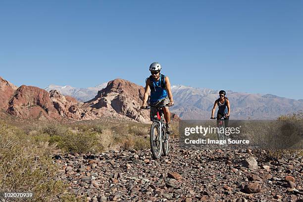 man and woman mountain biking in rocky terrain - mendoza stock pictures, royalty-free photos & images