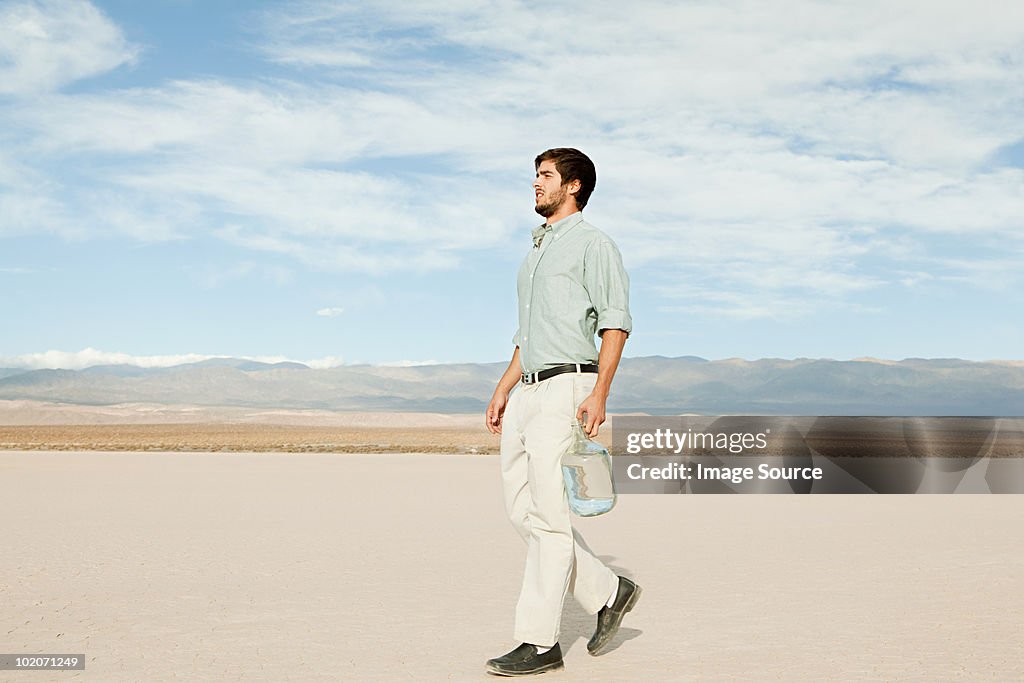 Man in desert landscape with bottle of water