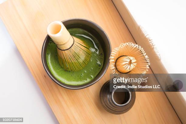 organic matcha in black bowl with traditional whisk - matcha tea stock pictures, royalty-free photos & images