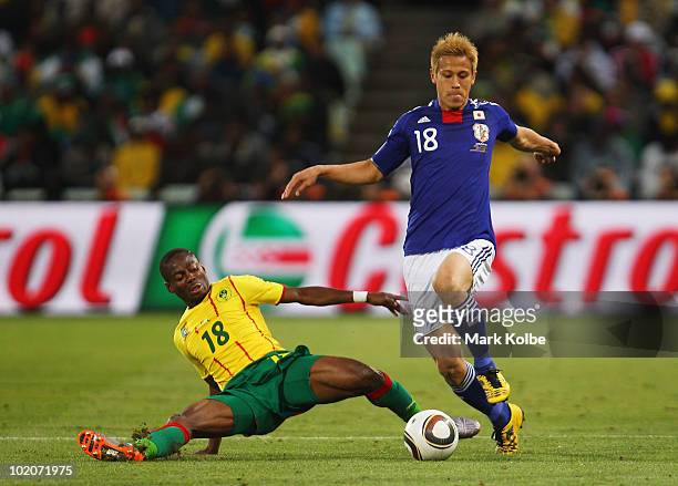 Enoh Eyong of Cameroon tackles Keisuke Honda of Japan during the 2010 FIFA World Cup South Africa Group E match between Japan and Cameroon at Free...