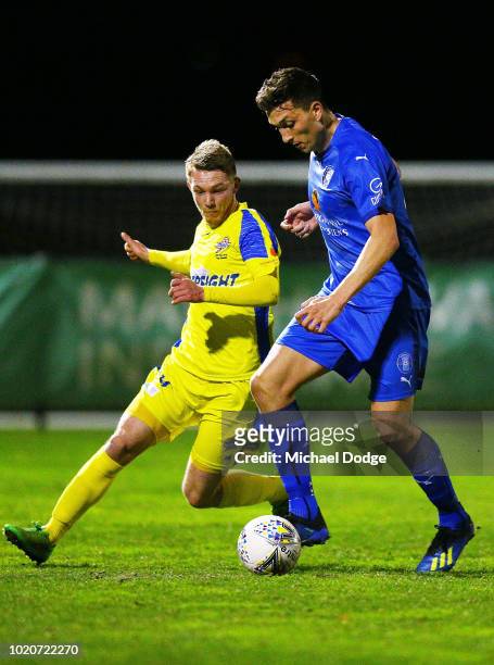 Liam Boland of Avondale kicks the ball at goal against Michael HOLDEN of Devonport during the FFA Cup round of 16 match between Avondale FC and...