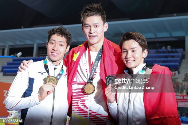 Silver medallist Naito Ehara of Japan, gold medallist Sun Yang of China and bronze medallist Kosuke Hagino of Japan celebrate during the victory...