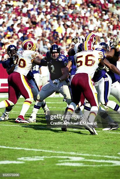 Offensive Lineman Mike Flynn of the Baltimore Ravens makes a hole for the offensive runner off of Defensive End Kenard Lang and Linebacker LaVar...