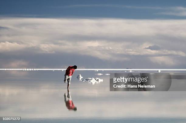 reflection of a man in water, salar de uyuni, bolivia - bolivia daily life stock pictures, royalty-free photos & images