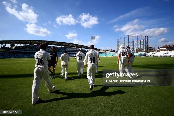 Surrey players make their way to the field during day three of the Specsavers County Championship Division One match between Surrey and Lancashire at...