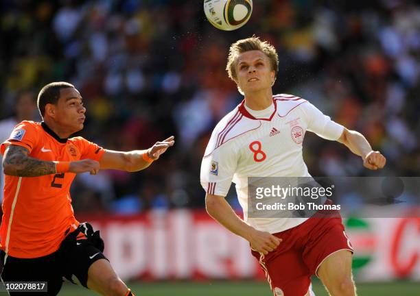 Jesper Gronkjaer of Denmark heads the ball while watched by Gregory Van Der Wiel of the Netherlands during the 2010 FIFA World Cup Group E match...