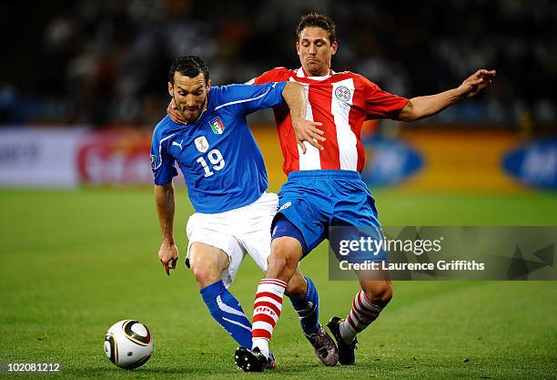 Gianluca Zambrotta of Italy tangles with Jonathan Santana of Paraguay during the 2010 FIFA World Cup South Africa Group F match between Italy and...