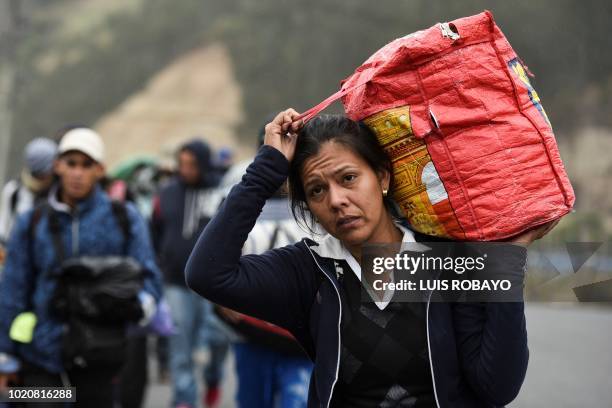 Venezuelan migrant woman heading to Peru carries a bag as she walks along the Panamerican highway in Tulcan, Ecuador, after crossing from Colombia,...