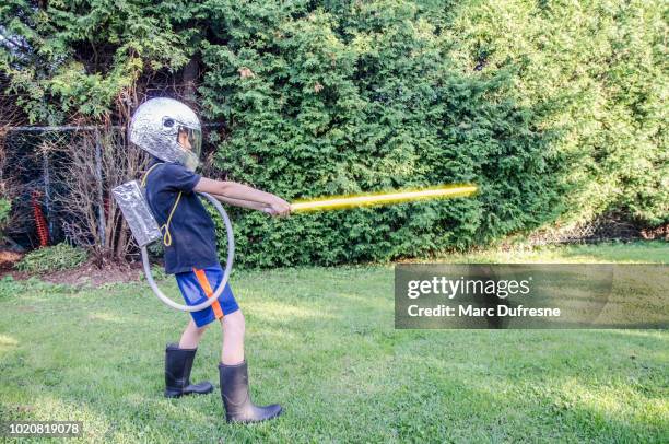 young boy dressed as an astronaut in the backyard during summer day - laser sword stock pictures, royalty-free photos & images