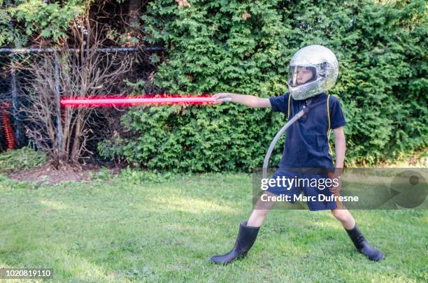 young boy dressed as an astronaut in the backyard during summer day - laser sword stock pictures, royalty-free photos & images