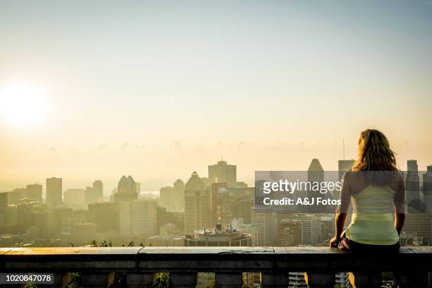 femme regardant le lever du soleil sur la ville - montréal photos et images de collection