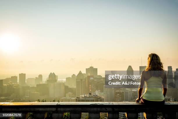 vrouw op zoek bij zonsopgang over de stad - montreal city stockfoto's en -beelden