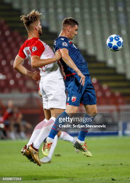 Nikola Stojiljkovic of Crvena Zvezda is challenged by Marin Pongracic of Red Bull Salzburg during the UEFA Champions League Play Off First Leg match...
