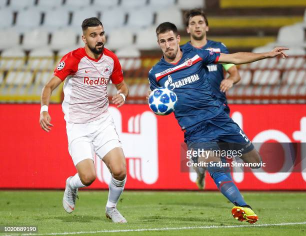 Milos Degenek of Crvena Zvezda in action against Munas Dabbur of Red Bull Salzburg during the UEFA Champions League Play Off First Leg match between...