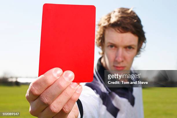 football referee holding up red card card in focus - red card stock pictures, royalty-free photos & images