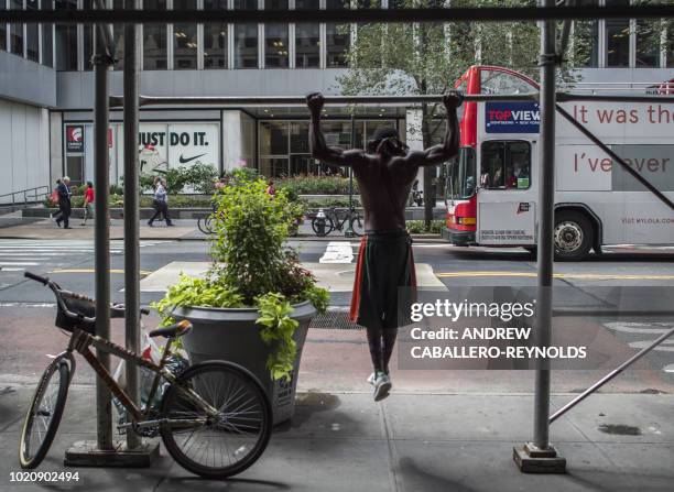 Man stops to do pull-ups on construction scaffolding in New York on August 21, 2018.