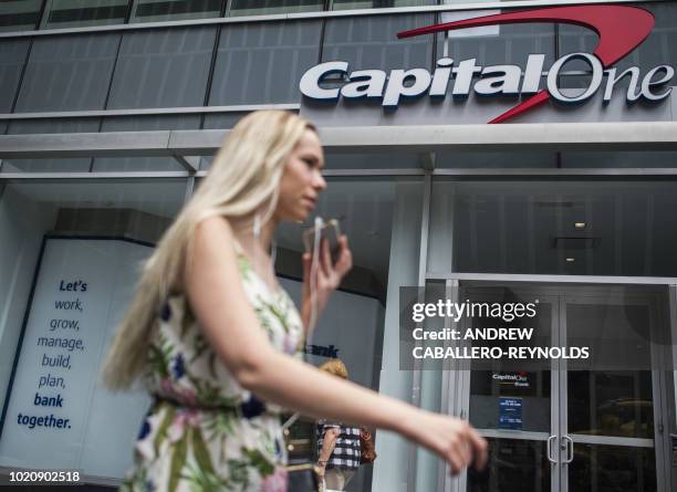 Woman talks on the phone as she walks past a Capital One bank branch in New York on August 21, 2018.