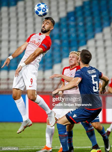 Munas Dabbur of Red Bull Salzburg jump for the ball against Milos Degenek of Crvena Zvezda during the UEFA Champions League Play Off First Leg match...