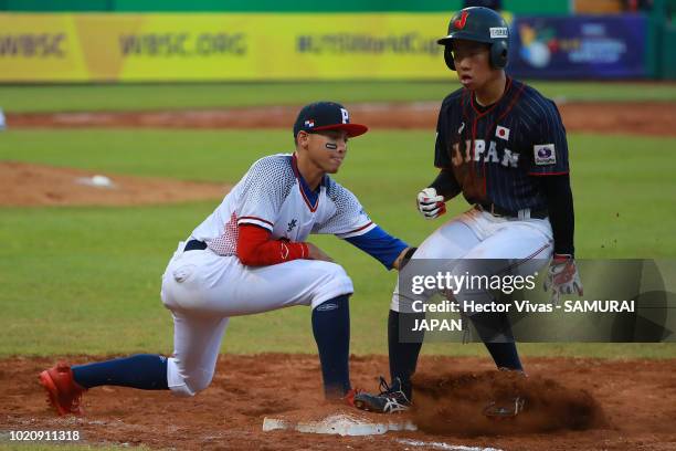 Hiromu Joshita of Japan slides safely into first base against Edwin Hidalgo of Panama in the 4th inning during the WBSC U-15 World Cup Super Round...