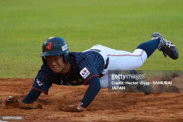 Hiromu Joshita of Japan slides safely into first base in the 4th inning during the WBSC U-15 World Cup Super Round match between Japan and Panama at...