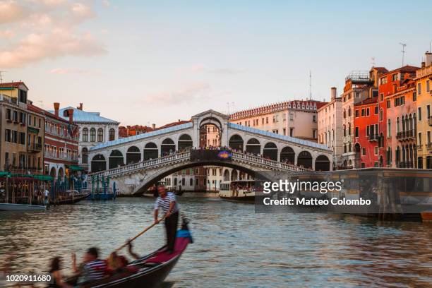 gondolier near rialto bridge, venice, italy - venice with couple stock pictures, royalty-free photos & images