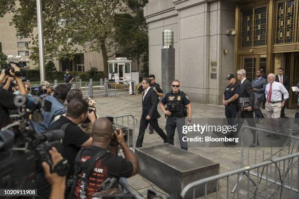 Michael Cohen, former personal lawyer to U.S. President Donald Trump, center, exits from federal court in New York, U.S., on Tuesday, Aug. 21, 2018....