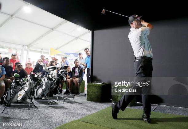 Tour golfer Ryan Palmer takes a swing in the golf simulator at The First Tee Experience At The Northern Trust at Ridgewood Country Club on August 21,...