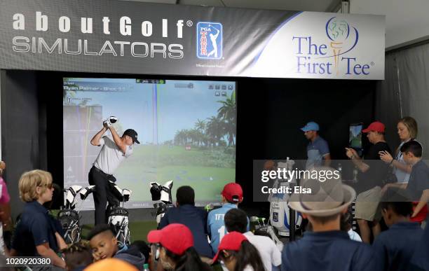 Tour golfer Ryan Palmer takes a swing in the golf simulator at The First Tee Experience At The Northern Trust at Ridgewood Country Club on August 21,...