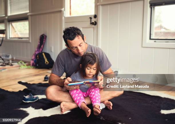 dad helps toddler daughter read - colorado home stock pictures, royalty-free photos & images