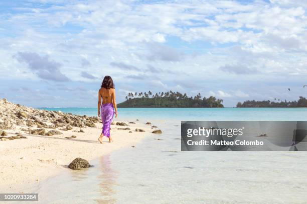 tourist with sarong on a beach, rarotonga, cook islands - isole cook foto e immagini stock